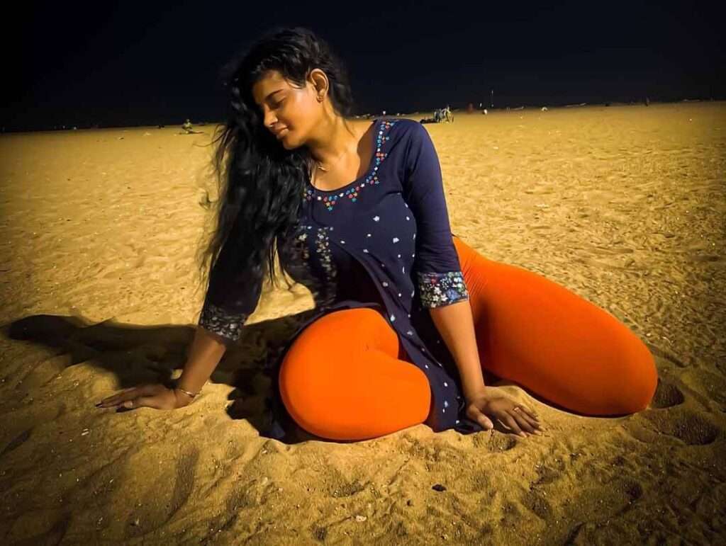 Preethi Indrani wearing leggings and top set and silk crepe shirt while she is on the beach