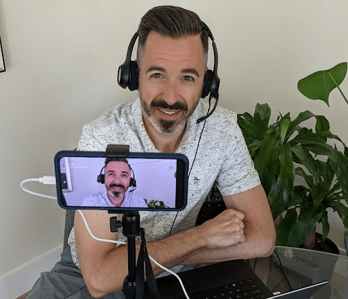 Rand smiling towards mobile camera while recording his video