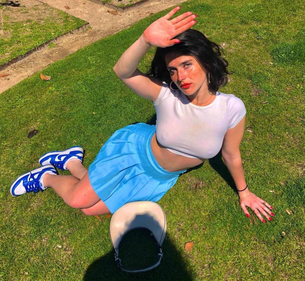 Alice in a reformation mini dress pair with Nike joggers while taking a sun kissed photo