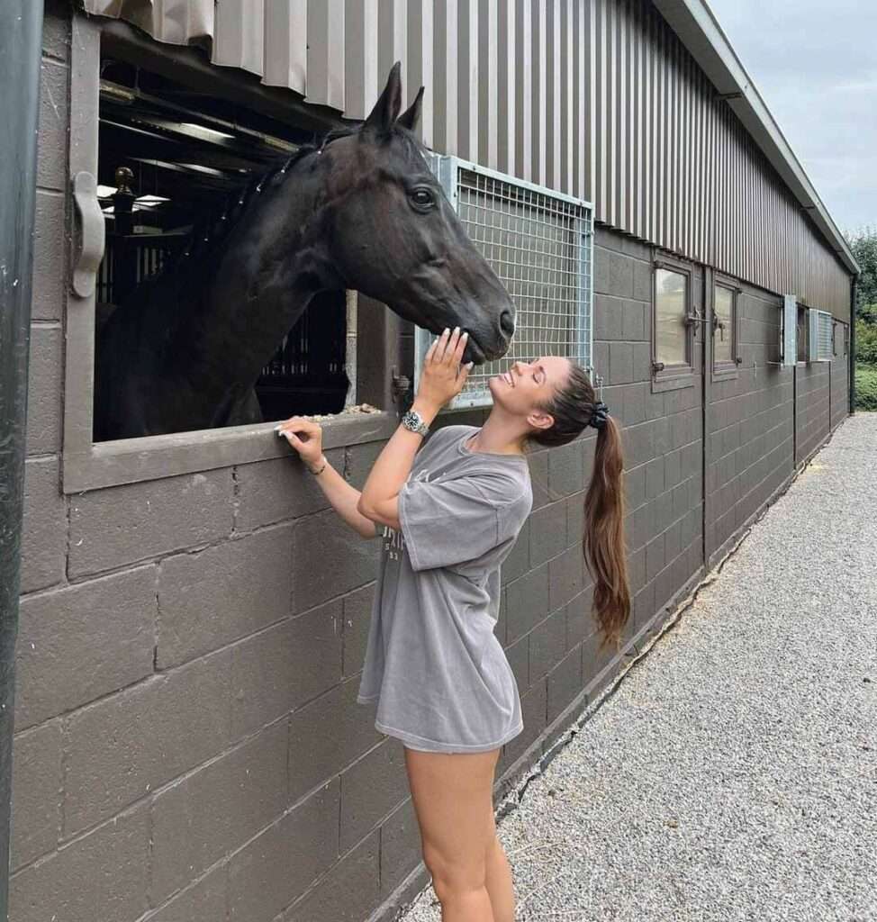 Erin-Williams in a grey t-shirt with panty while smiling towards horse