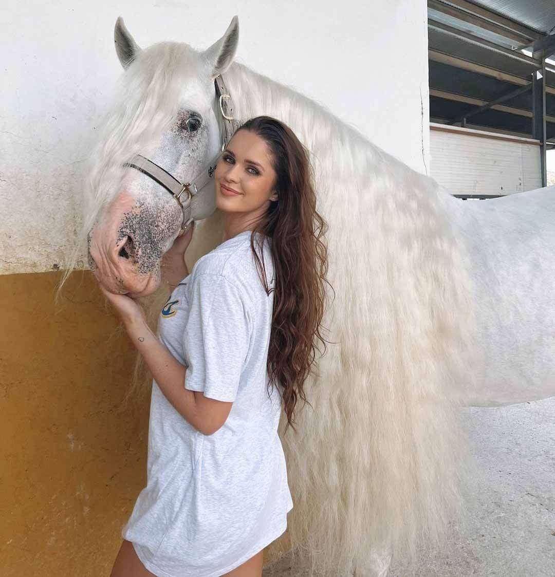 Erin-Williams wearing a white , grey mix t-shirt while twining with her adorable horse