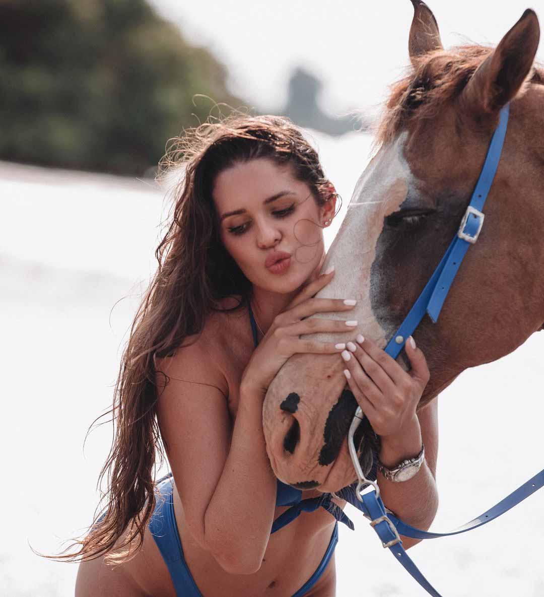 Erin-Williams in a mini crop top with panty while holding her horse face
