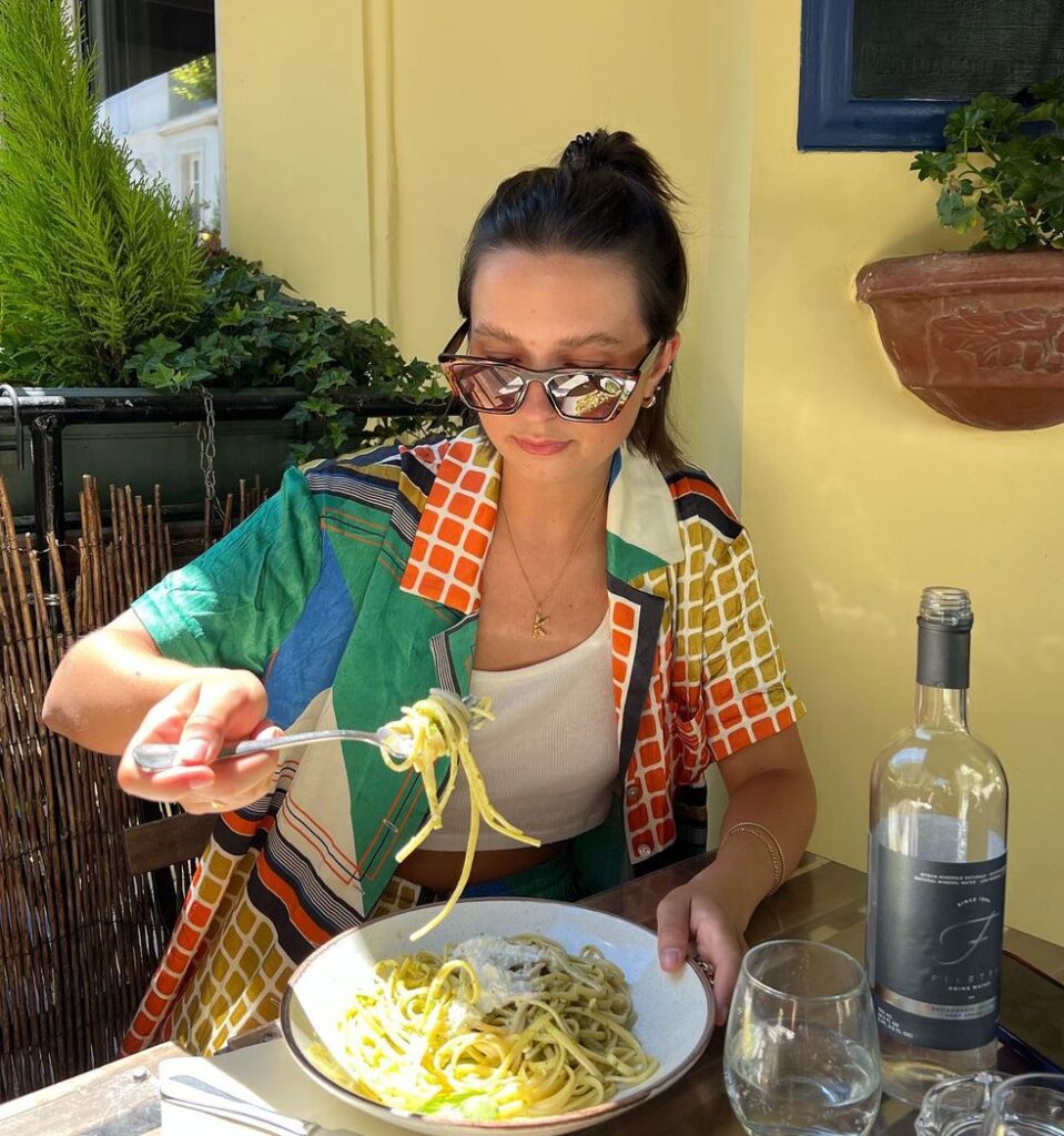 Kelsey-Kotzur in a white inner shirt with green dress shirt while taking her meal.