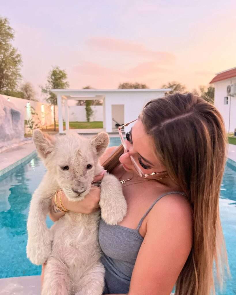 Lilith Cavaliere in a grey stripped top while holding her pet