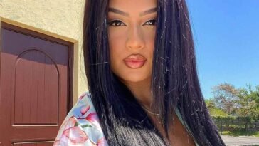 Lucero crystal in a printed top while taking a selfie