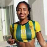 Qimmah Russo in a sports crop shirt with wet hairs smiling towards camera