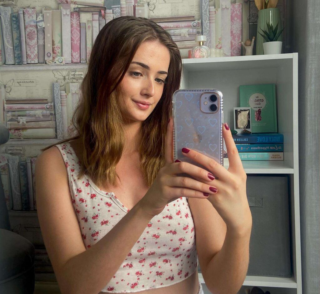 Amber Dunn in a floral print crop top while taking selfie in the front of mirror