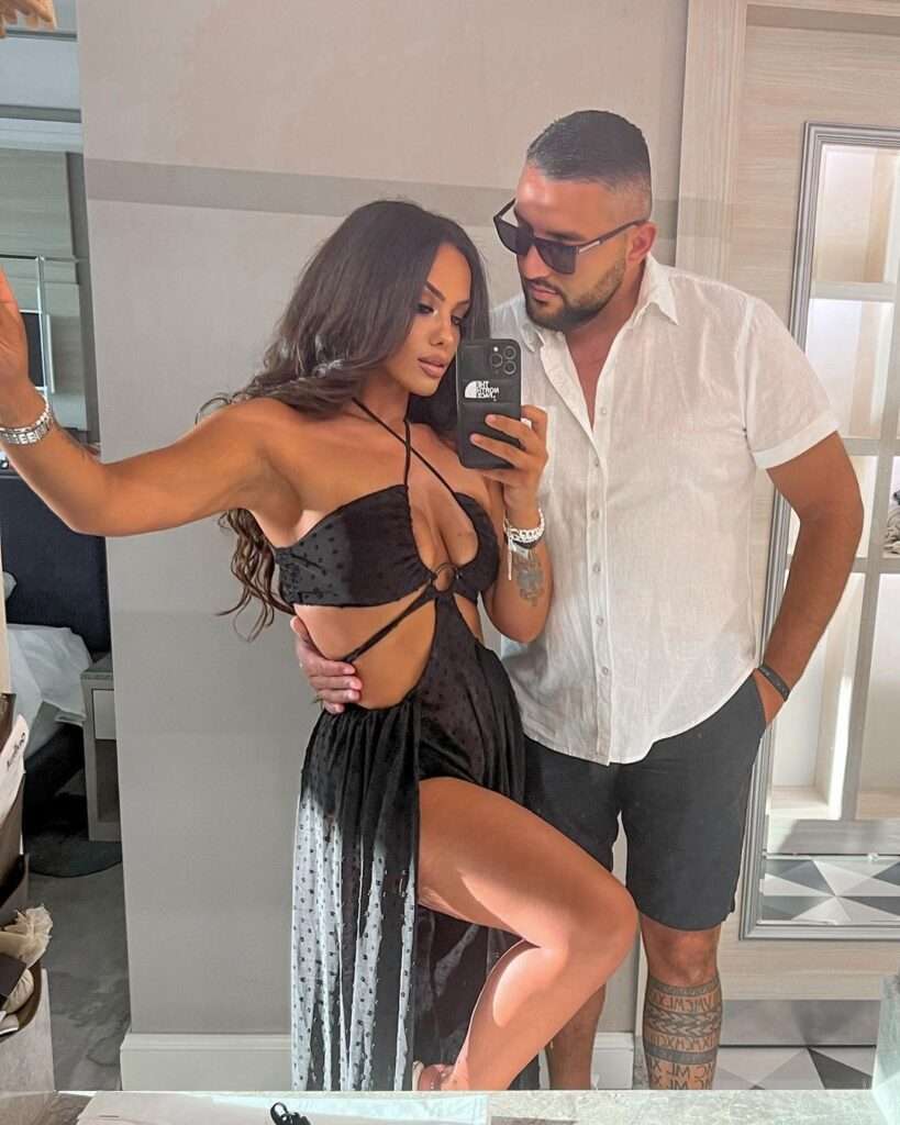 Antelainta DH. in a sexy reformation style dress while taking a selfie with her boyfriend in the front of mirror