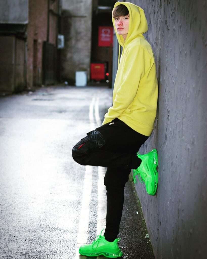 Joseph Oconnor Joe-mjj in yellow hoodie showing his clothing brand on his Instagram. 