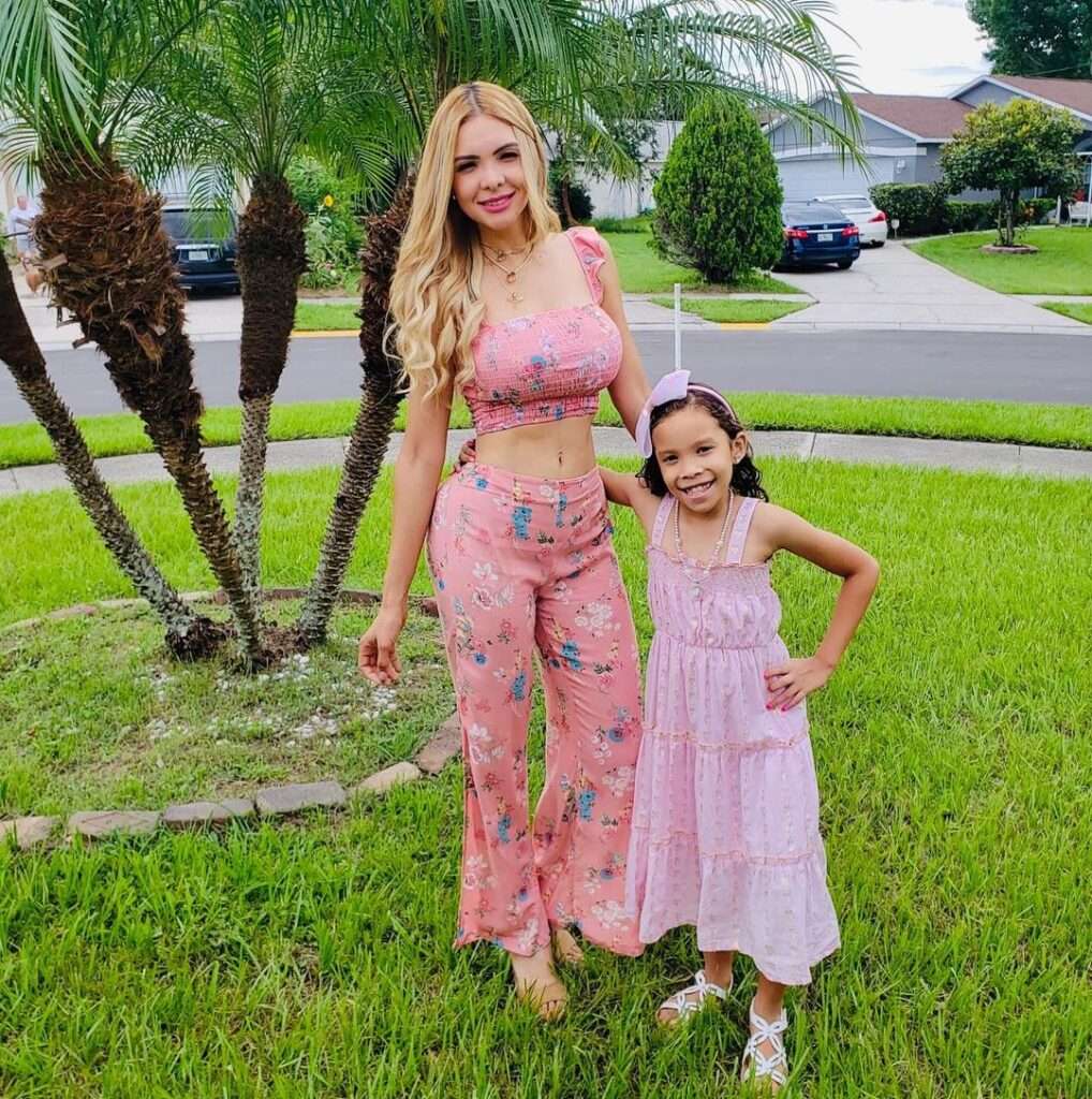 Madeleine in a printed crop top pair with matching bell bottom trouser while taking picture with her daughter