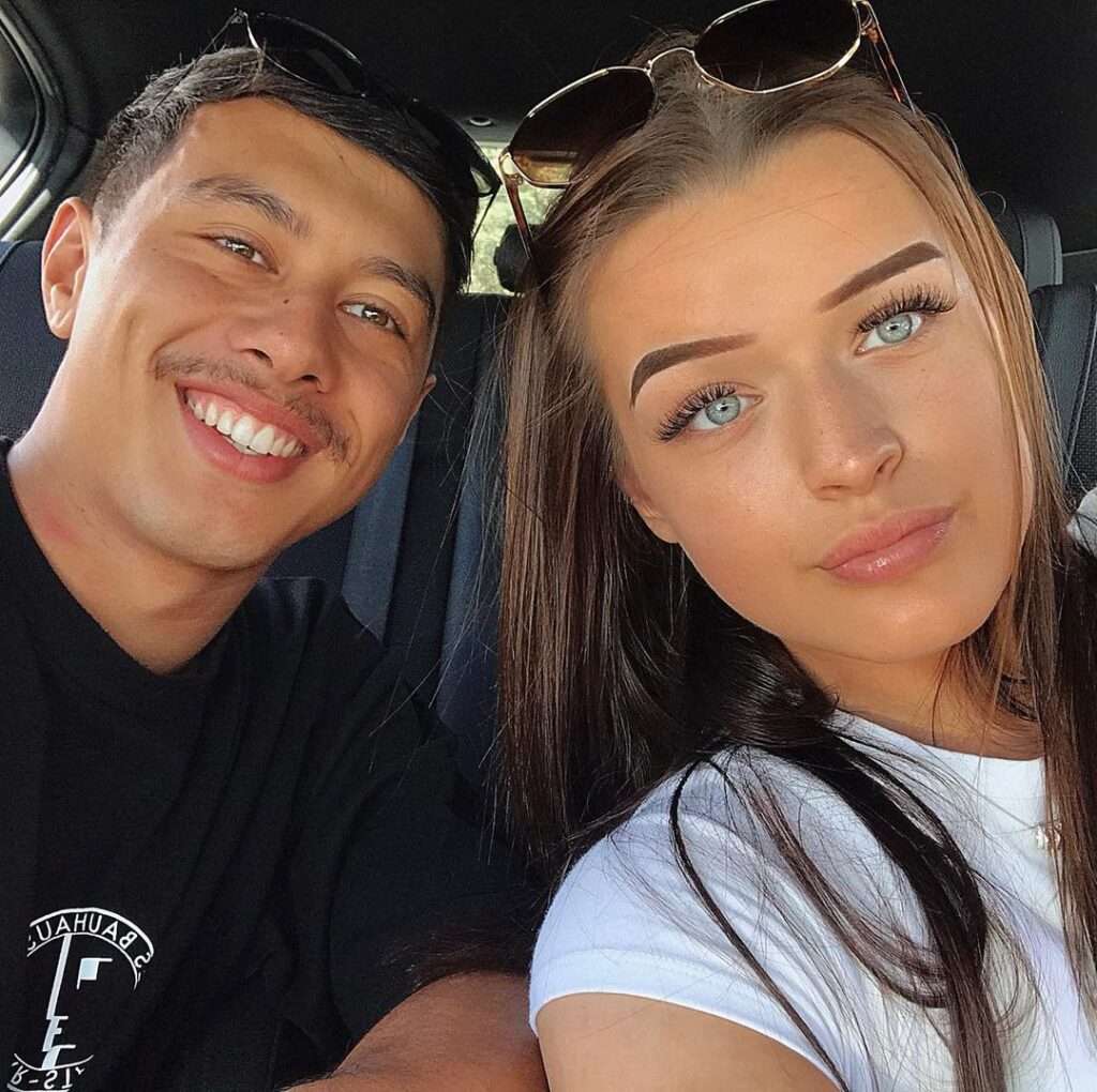 Tui jones in a white t-shirt while taking selfie with her boyfriend in the car