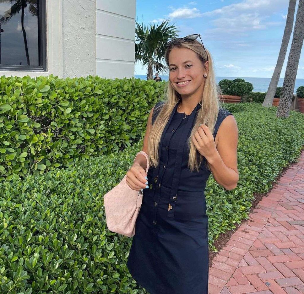 Yulia Putintseva in the stunning black outfit pair with pink bag while smiling towards camera