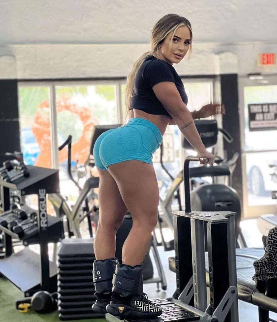 Mia Rivero is looking cute in crop shirt with blue shorts standing in a gym during workout.