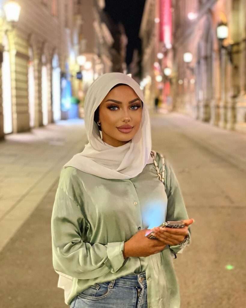 IIso Abyy looking fabulous, standing in a street for a photoshoot while wearing a hijab with pastel shirt and blue denim pant.