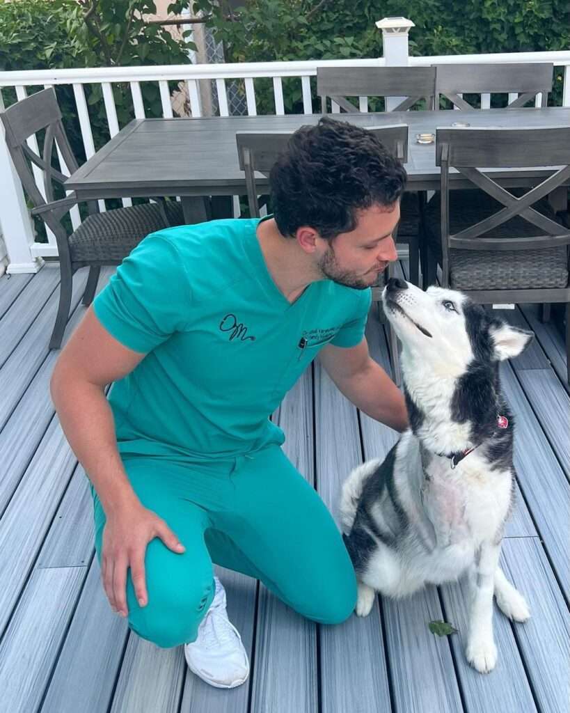 𝐃𝐫. 𝐌𝐢𝐤𝐞 in a turquoise blue t-shirt with matching trouser while looking at his dog