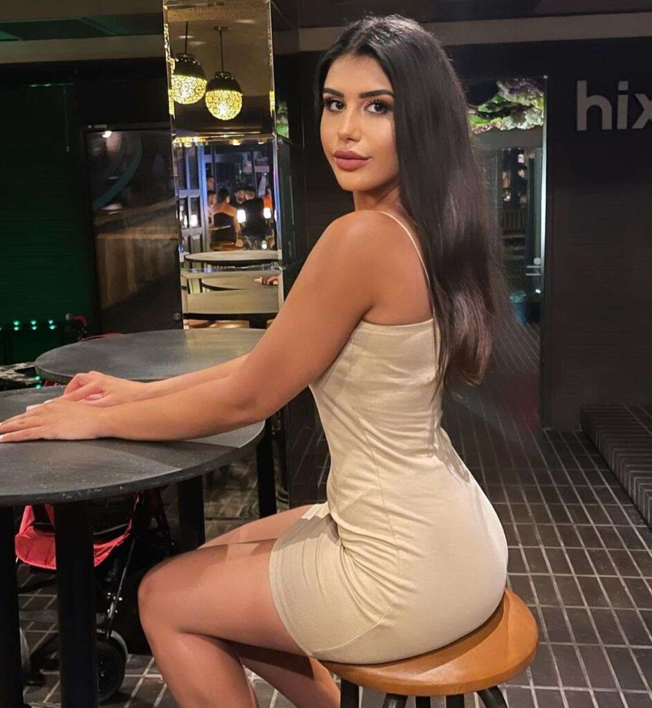 Bahar Dior in the sexy creamy white bodycon while sitting on the too and looking towards camera
