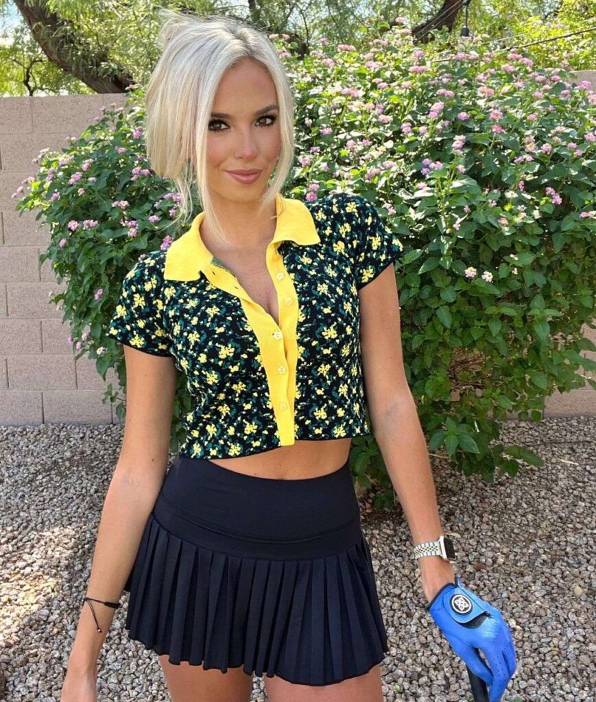 Elise Lobb Dzingel wearing a open crop shirt with mini skirt while poses for a picture