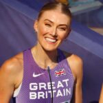 Ellie Baker in a purple football costume while smiling towards camera