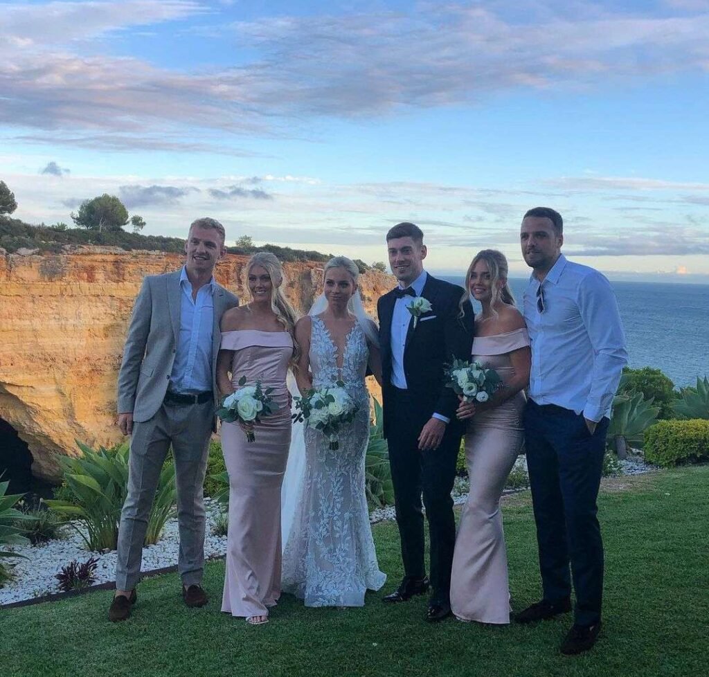 Ellie Baker in a beautiful maxi style dress while taking a group photo on her brother wedding