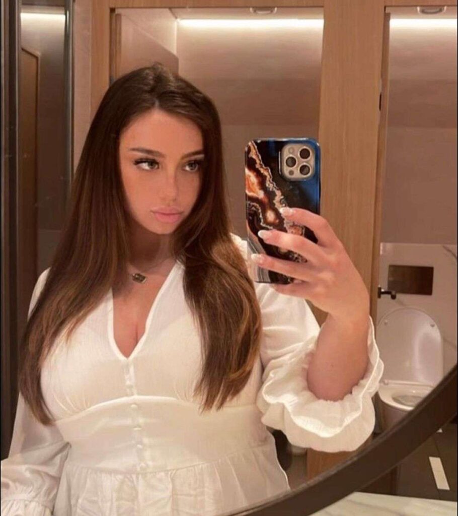 Juicy jade wearing a white top while taking a picture in the front of mirror