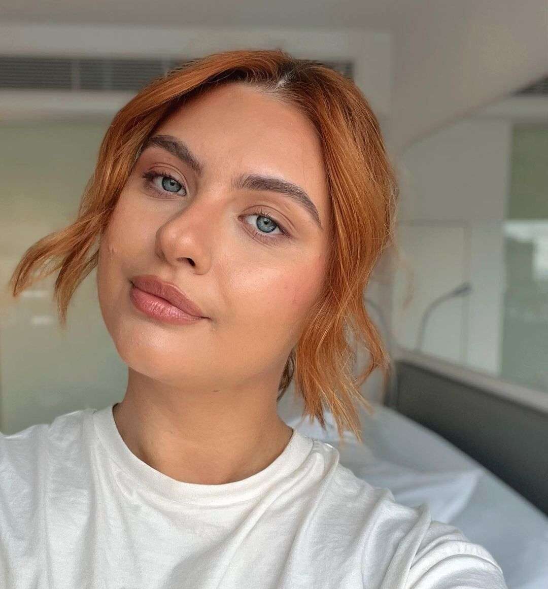 Julia in a white t-shirt while taking a selfie