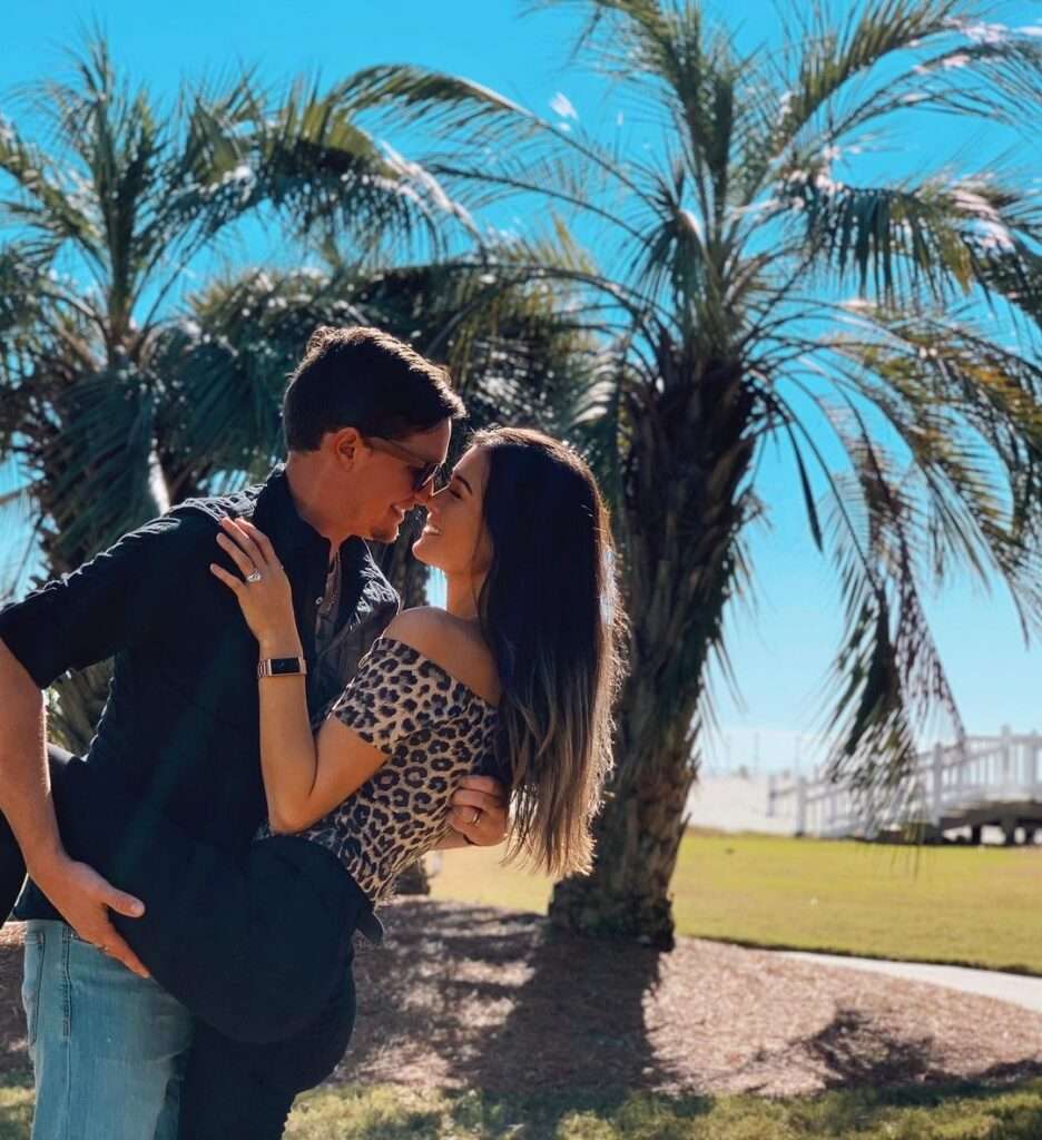 Keilah Kang in a the tiger print shirt with black pants while taking picture with her husband
