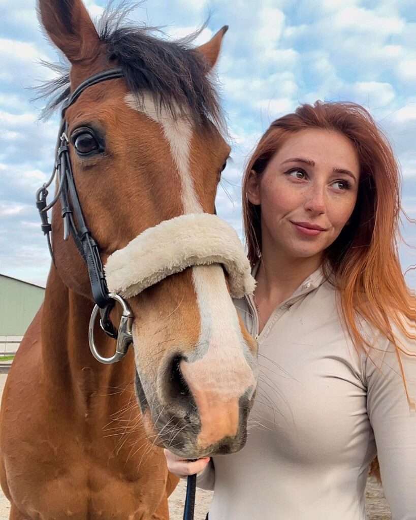Melissa Carroll in a beautiful pastel shade shirt while taking picture with her horse