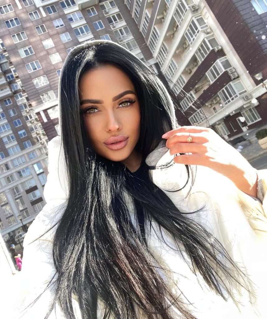 Aleksiya is looking attractive while wearing a white hoodie and with straight black hair.