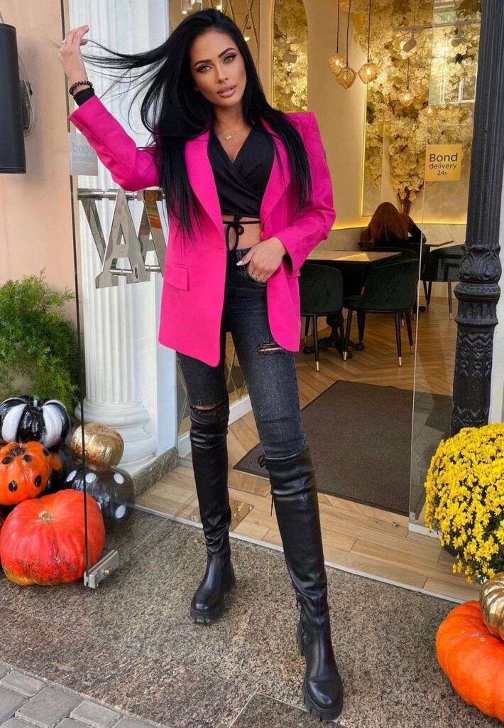 Aleksiya is a Ukrainian fashion model and here she is wearing a crop shirt with jeans and pink coat standing outside a restaurant.
