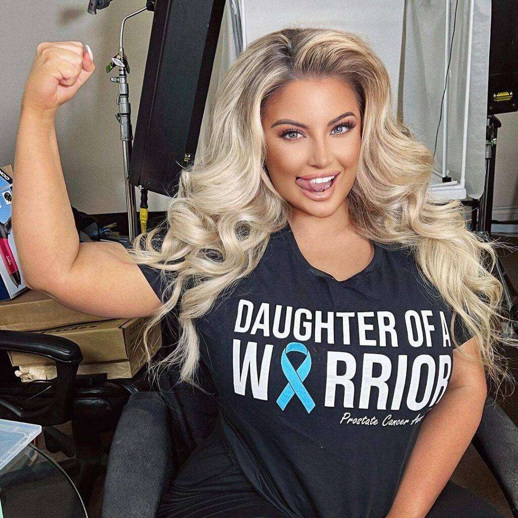 Ashley Alexiss in a black t-shirt with black leggings while poses for a photo