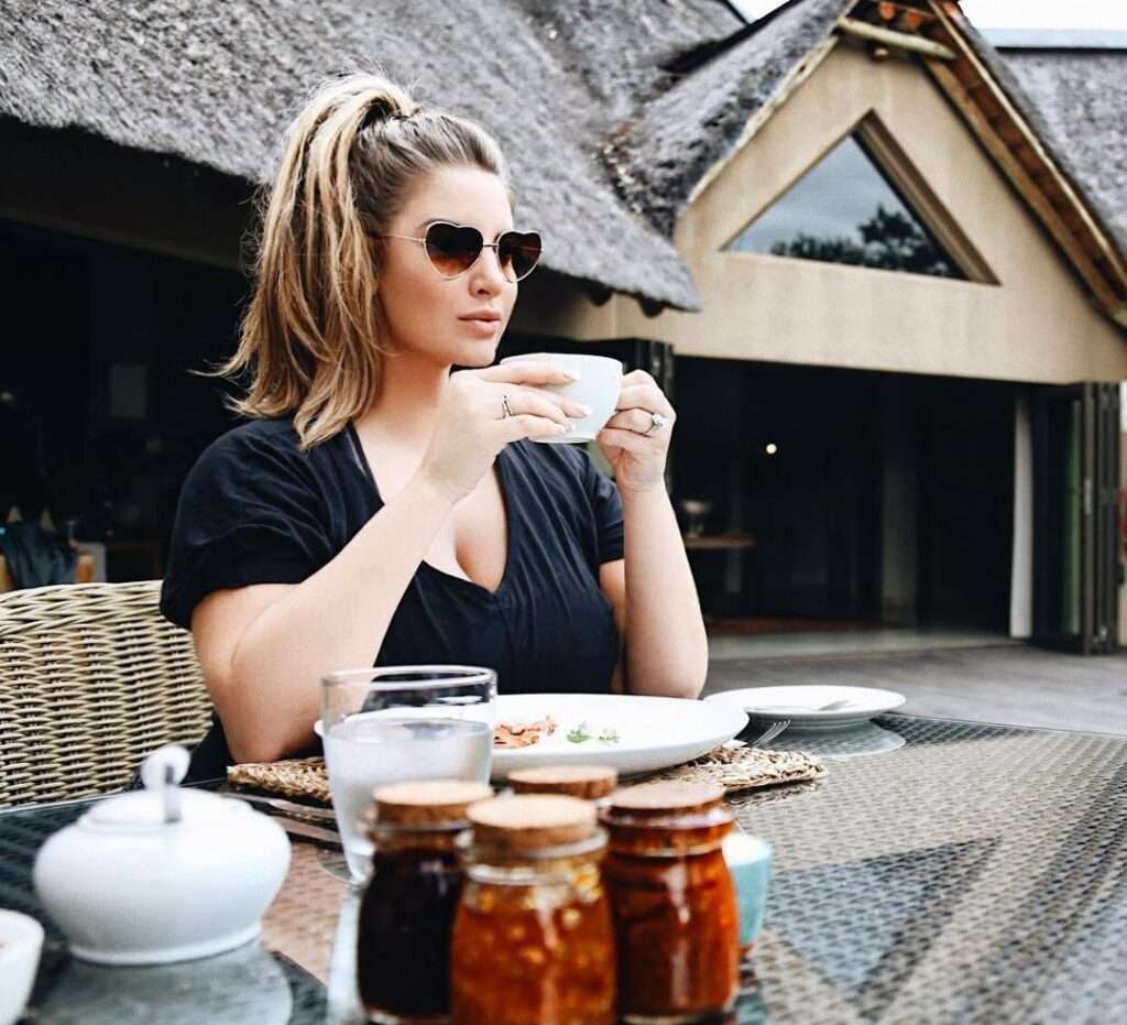 Ashley Alexiss in a black top pair with goggles while taking coffee