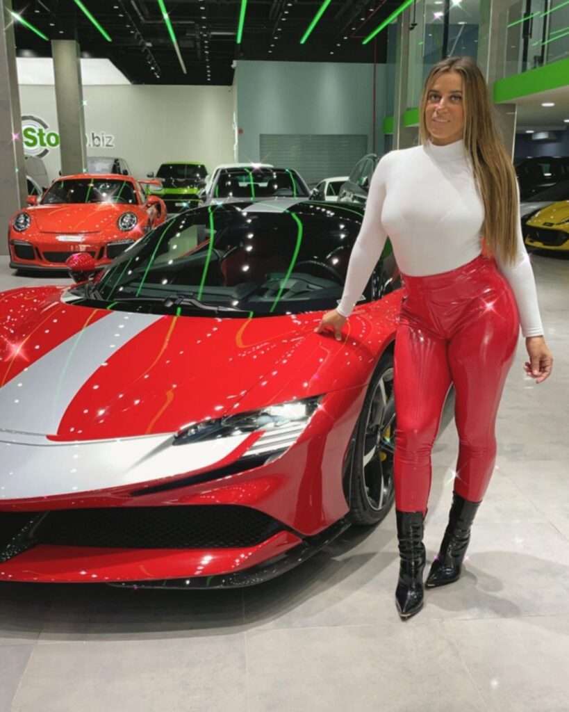 Bestone Paris is looking hot while standing beside a Ferrari and wearing a latex dress match to her car.