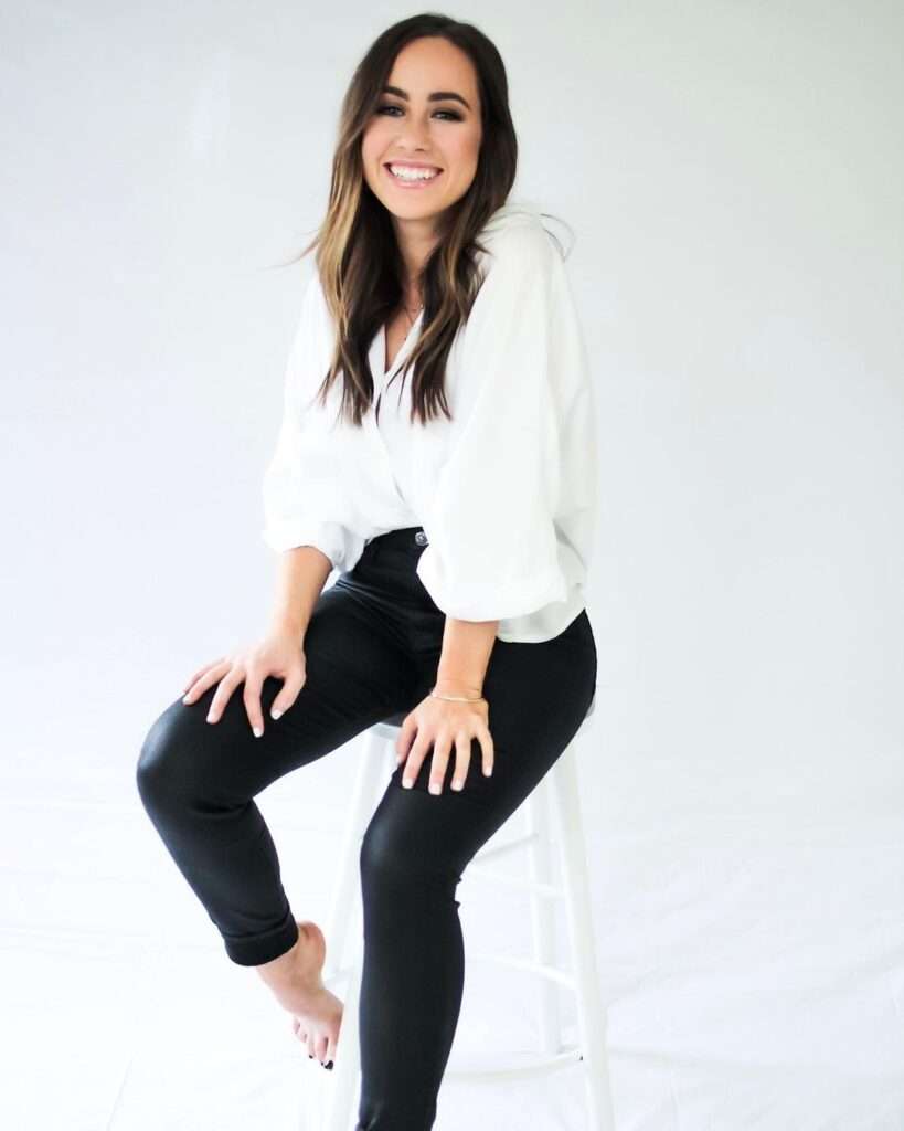 By Sophia Lee is sitting on a stool and is posing for a picture while wearing a pant-shirt looking cute here.