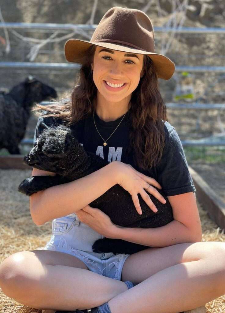 Colleen Ballinger is just posing for a picture while holding a sheep as she loves animals a lot.