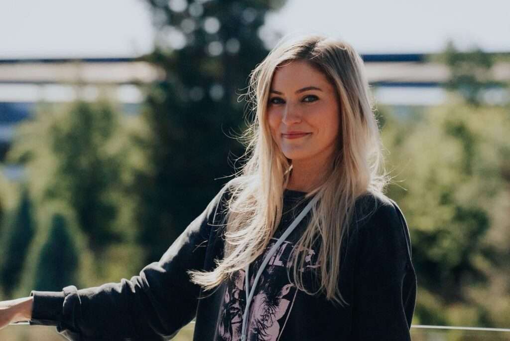 iJustine is smiling and enjoying her vacations while wearing a shirt. she looks so relaxed and happy.