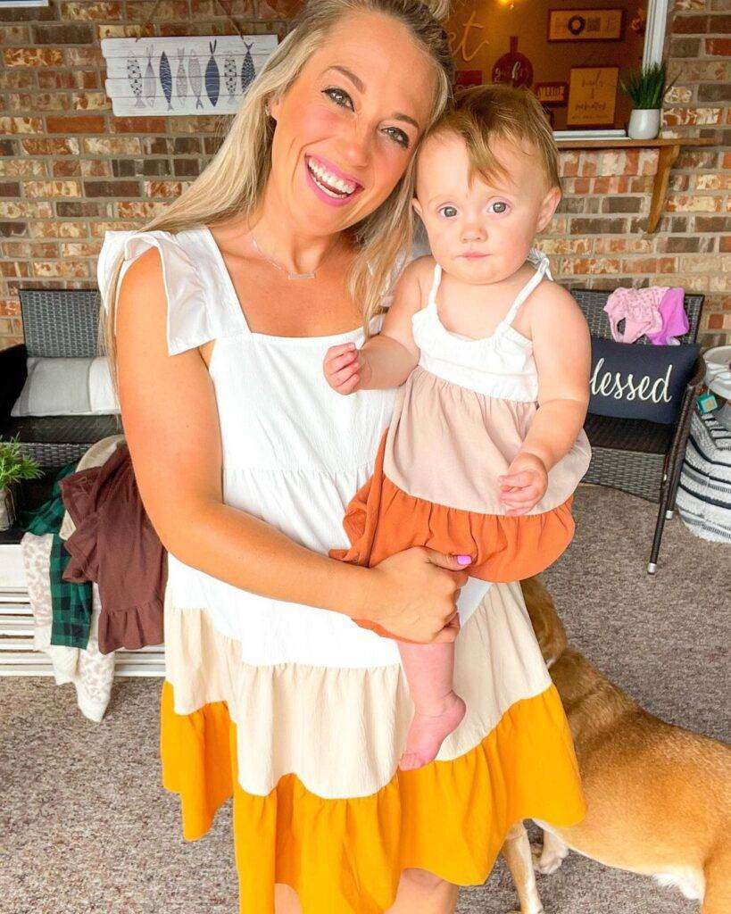 Kenzie Jo Clark is with her baby girl while wearing a tank top as they both are wearing same dresses.