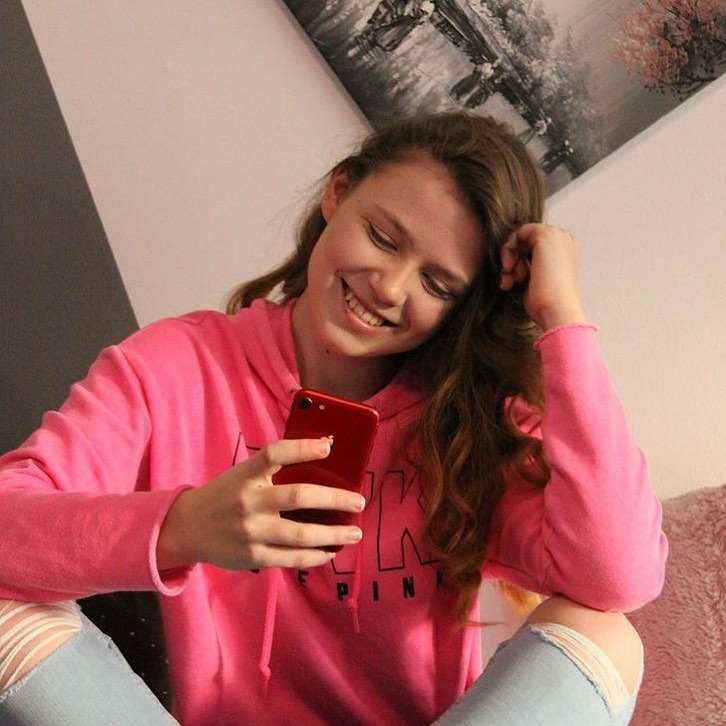 Latynnxx is in pink hoodie posing for picture and is just giving her cute smile.