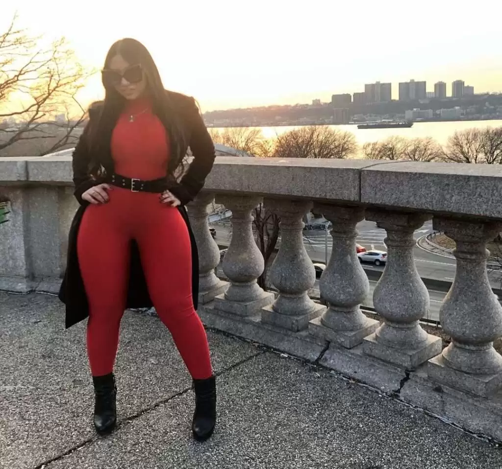 Marleny Nunez in the red stunning outfit with black over coat, boots, and goggles