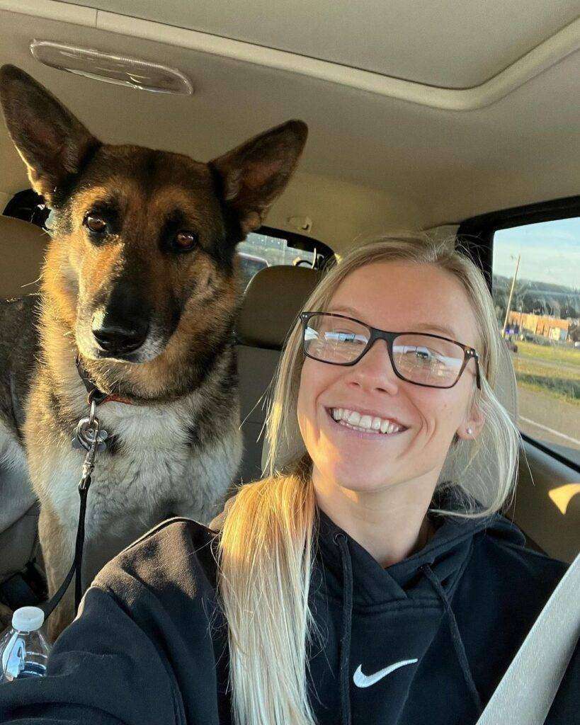 Mealsandmunchies is sitting in a car and taking a selfie with her dog she said she is a dog mom so taking selfie with her dog.