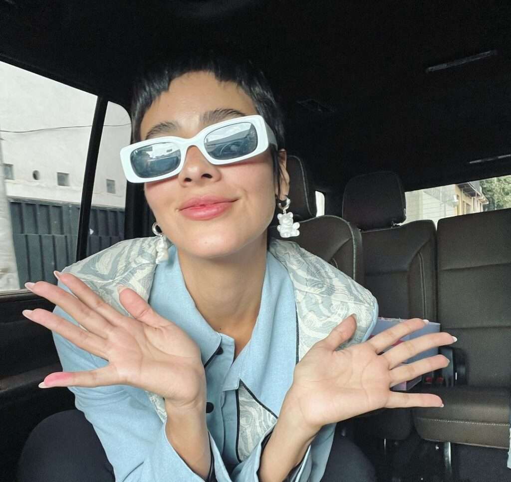 Esmeralda Pimentel in the blue dress with funky glasses while taking a picture
