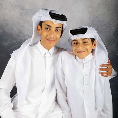 Ghanim Al-Muftah is just posing a picture with his brother and he is wearing a Thobe.