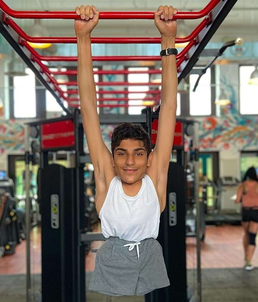 Ghanim Al-Muftah is at Gym as he loves sports and for sports he has to be strong so he is exercising in a gym.