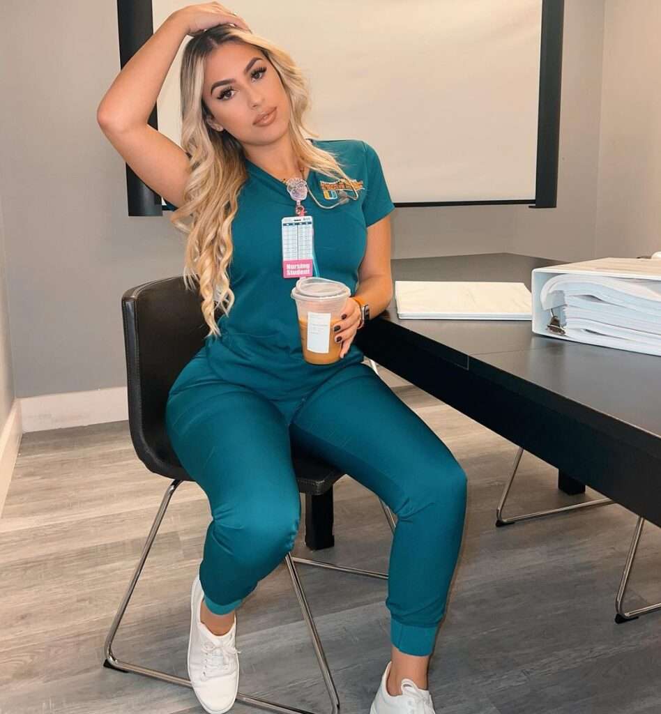 Gema Delgado in the green full dress pair with white joggers while holding a coffee in her hand and looking towards camera