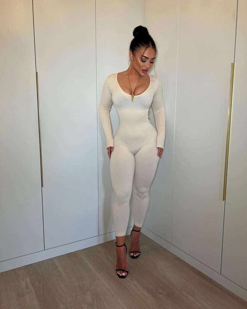 Kate Isobel in a beautiful white jumpsuit pair with black heels while taking a picture