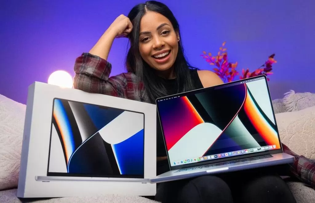 Krystal Lora is a tech-YouTuber and here she is talking about a laptop while posing for a picture.