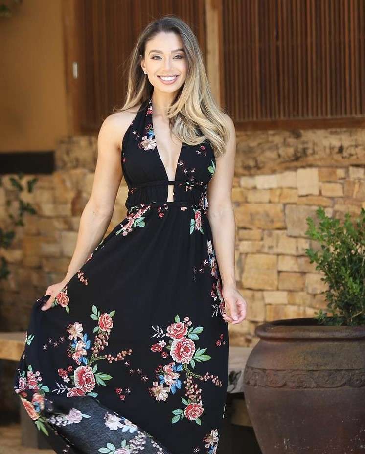 Lais De Leon is smiling and posing for a picture while wearing a black long frock.