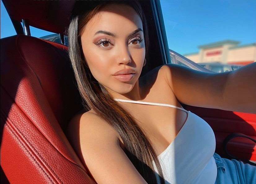 Starla Yancy in the striped white top pair with blue jeans while taking selfie in the car