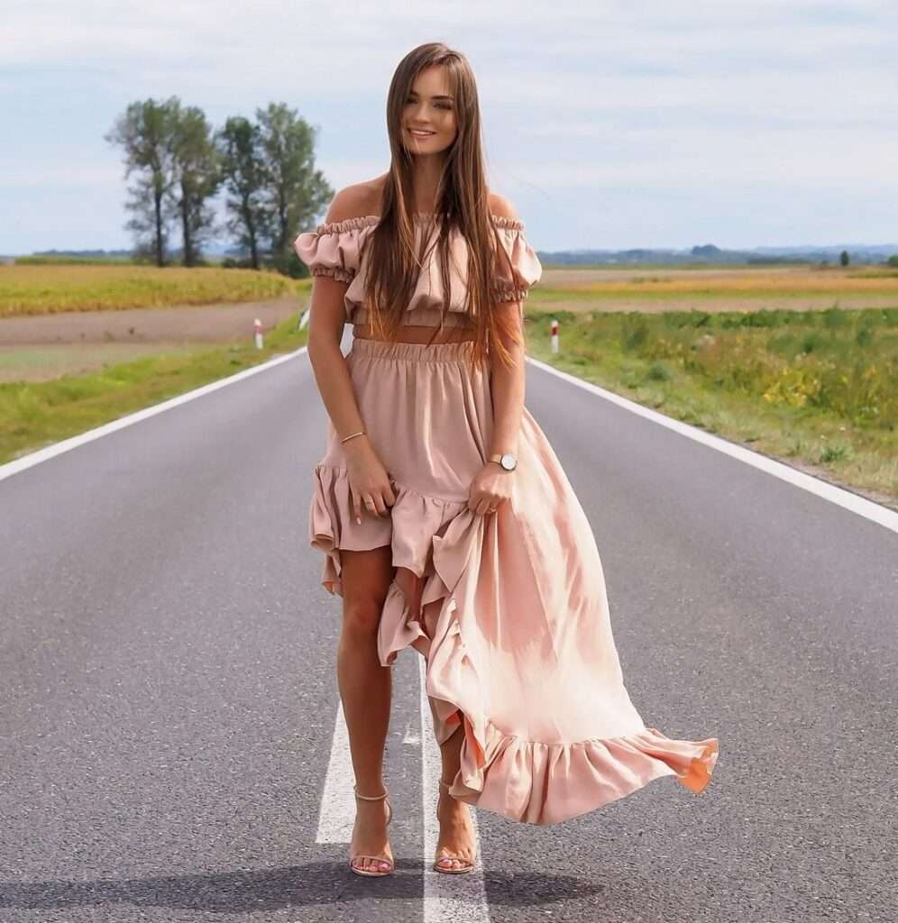 Sylwiaaa in the t-pink silk outfit while taking a photo on the road