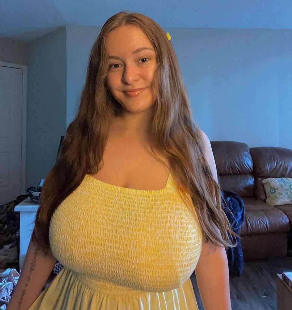 Arianna Perez in the yellow short frock while smiling towards camera for taking a photograph