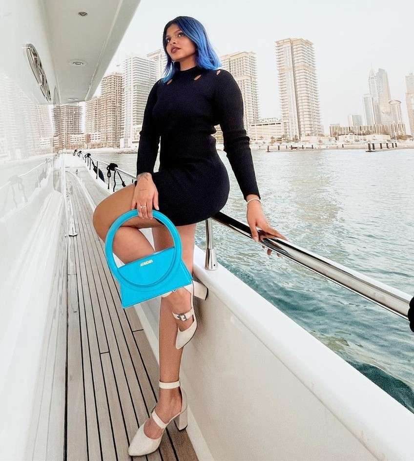 Mariam George is on vacation in Thailand and here she is sitting on a boat and is posing for a picture.